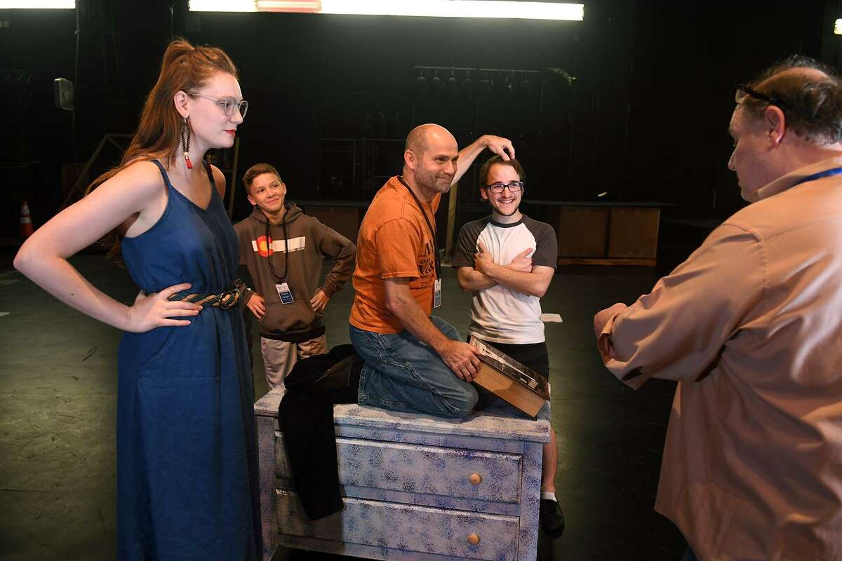 Courtney Berry, from left, of Spring, who takes the part of "The Ghost of Christmas Past", Peyton Kargel, 13, a 7th grader at Spillane Middle School, who will play his part as an "Acolyte", Brad Zimmerman, of Cypress, who will play "Scrooge", and Nathan Crooks, of Cypress, who will also play an "Acolyte", work a scene with Director Michael Montgomery, of Cypress, during a rehearsal of the upcoming Stageworks Theatre production of "A Christmas Carol" at The Lone Star College - Cy-Fair Performing Arts Center on Sept. 26, 2018.