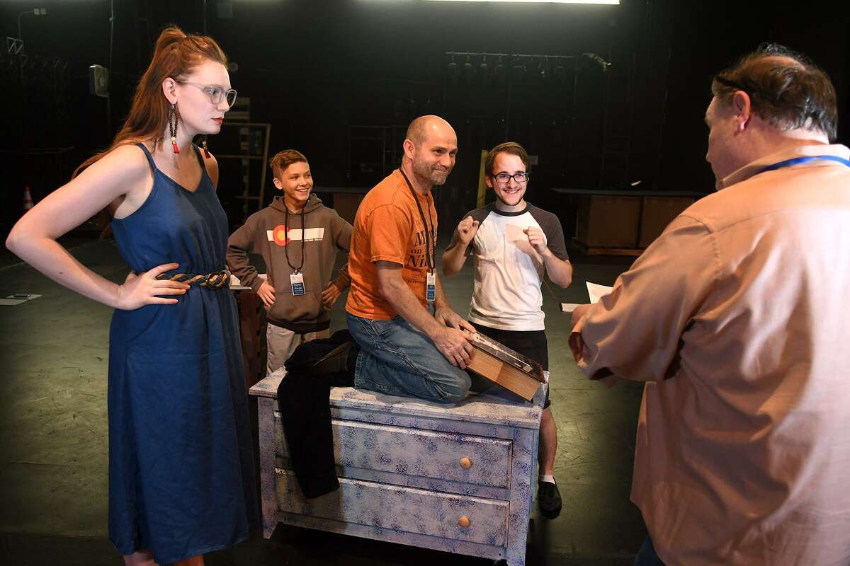 Courtney Berry, from left, of Spring, who takes the part of "The Ghost of Christmas Past", Peyton Kargel, 13, a 7th grader at Spillane Middle School, who will play his part as an "Acolyte", Brad Zimmerman, of Cypress, who will play "Scrooge", and Nathan Crooks, of Cypress, who will also play an "Acolyte", work a scene with Director Michael Montgomery, of Cypress, during a rehearsal of the upcoming Stageworks Theatre production of "A Christmas Carol" at The Lone Star College - Cy-Fair Performing Arts Center on Sept. 26, 2018.