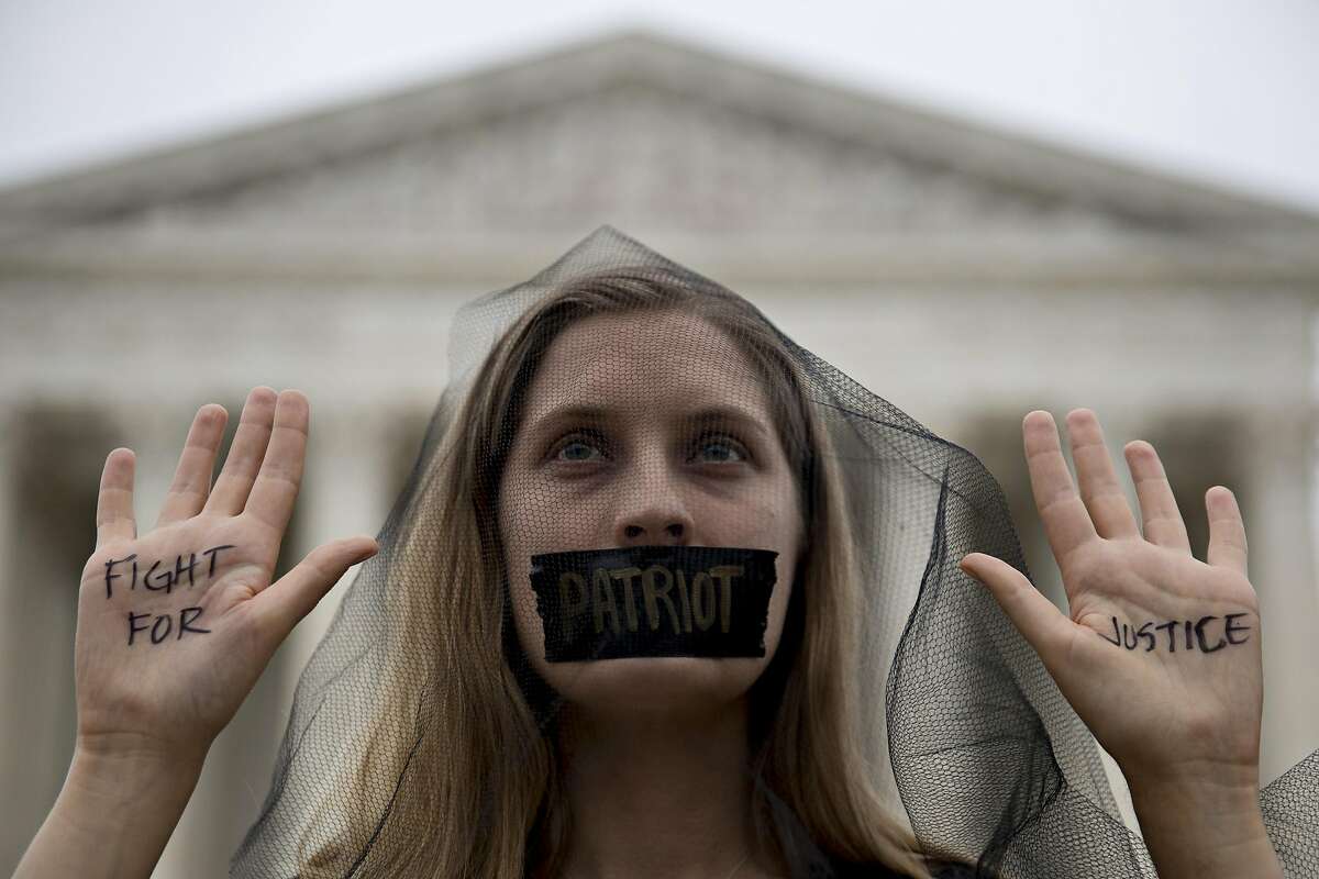 A demonstrator opposed to Supreme Court Associate Justice Brett Kavanaugh stands outside the court with "Fight For Justice" written on her hands in Washington, D.C., U.S., on Saturday, Oct. 6, 2018. Kavanaugh was confirmed to the U.S. Supreme Court after one of the most ferocious confirmation battles in history, overcoming allegations of school-age sexual assault and claims by Democrats that he was dishonest in Senate hearings. Photographer: Andrew Harrer/Bloomberg