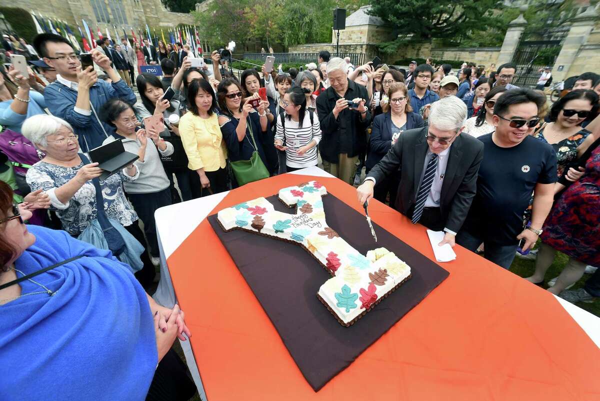 Yale University President Peter Salovey cuts a cake on Cross Campus in New Haven Tuesday during the fifth annual Founders Day, celebrating the founding of the university in 1701.
