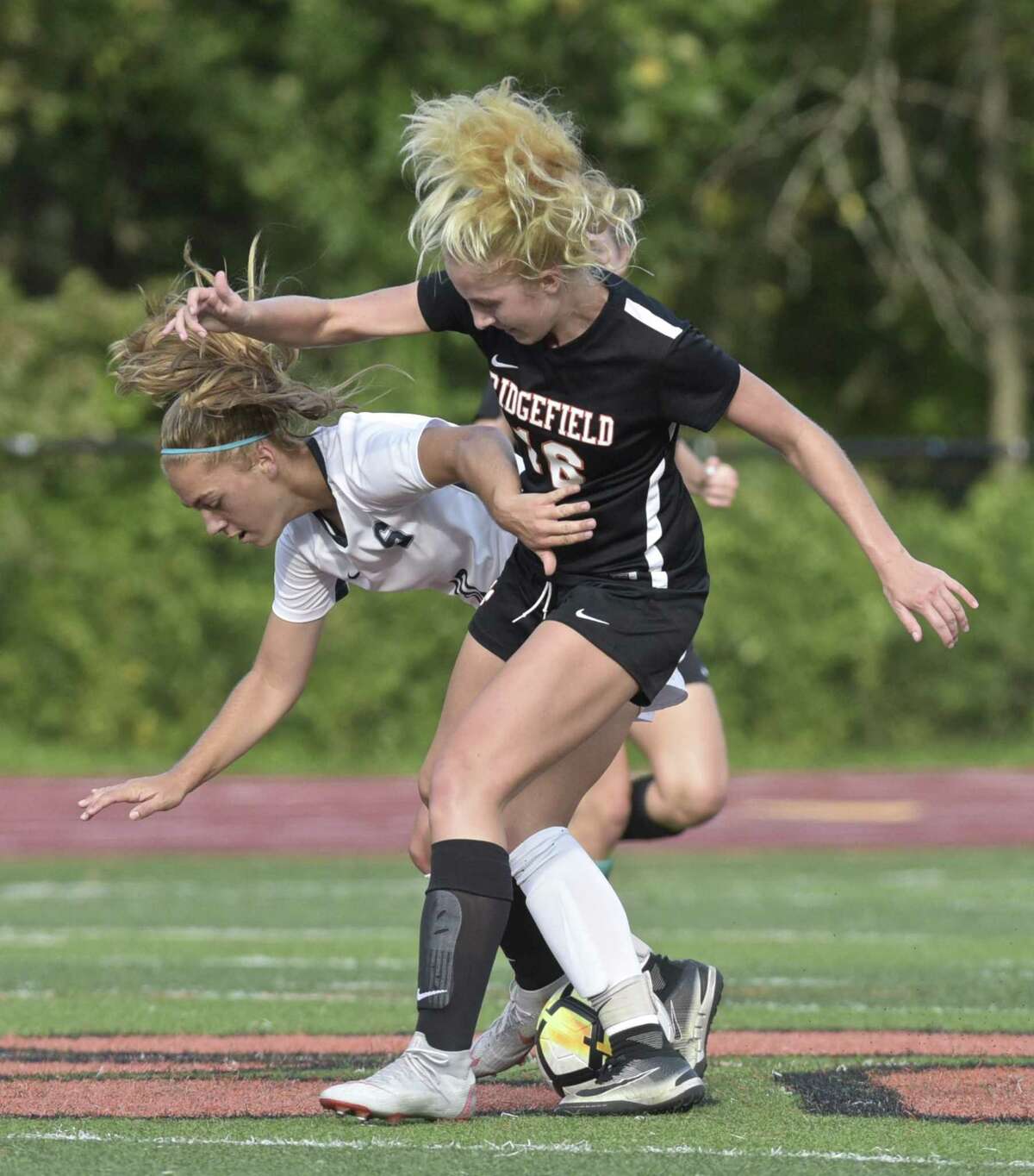 Staples' Ashley Wright (10) and Ridgefield's Meredith Clifford (16) battle over the ball in the girls soccer game between Staples and Ridgefield high schools, Tuesday afternoon, October 9, 2018 at Ridgefield High School, Ridgefield, Conn.