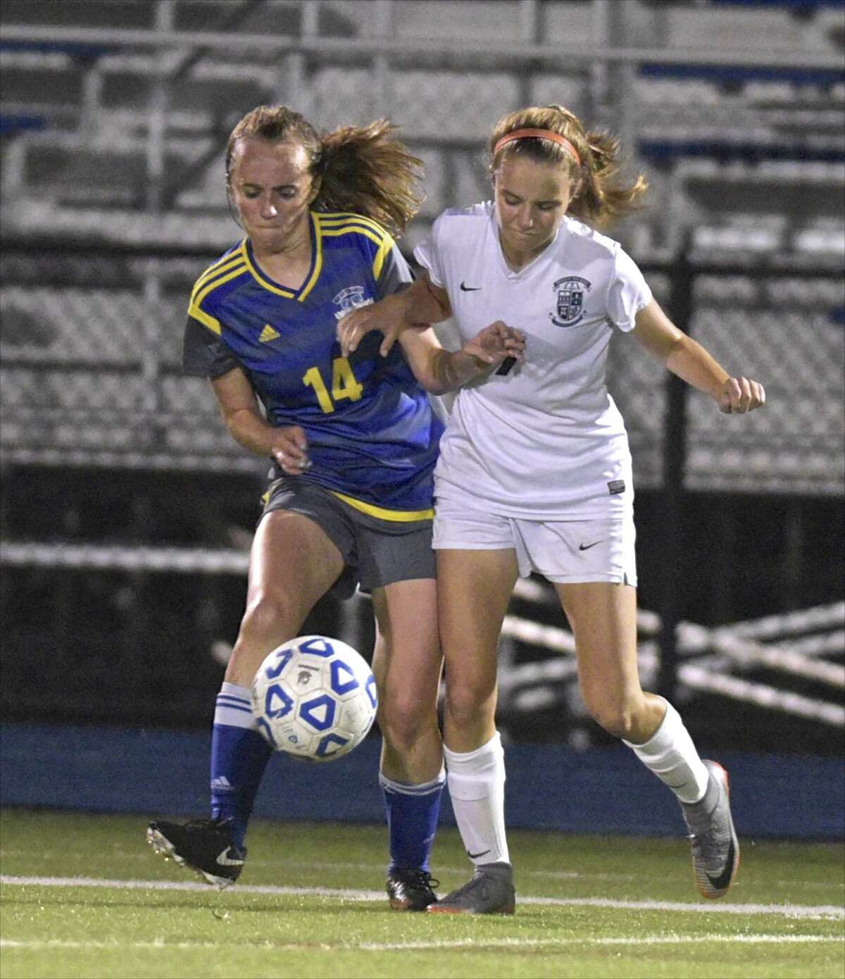 Newtown's Faith O'Hara (14) and Immaculate's Maddie Bourque (7) fight for the ball in the girls soccer game between Immaculate and Newtown high schools, Tuesday night, October 9, 2018 at Newtown High School, Newtown, Conn.