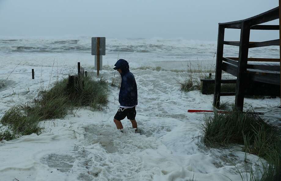 Cameron Sadowski walks along where waves are crashing onto the beach as the outer bands of hurricane Michael arrive on October 10, 2018 in Panama City Beach, Florida. The hurricane is forecast to hit the Florida Panhandle at a possible category 4 storm. Photo: Joe Raedle/Getty Images