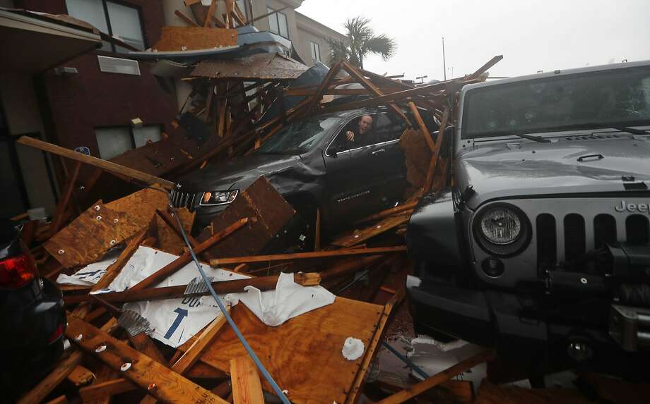 A storm chaser climbs into his vehicle during the eye of Hurricane Michael to retrieve equipment after a hotel canopy collapsed in Panama City Beach, Fla., Wednesday, Oct. 10, 2018. Photo: Gerald Herbert, Associated Press