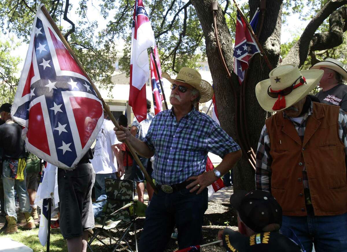A protester attending the rally hosted by the Texas Freedom Force stands tall holding his confederate flag on Saturday, Aug 12 at Travis Park as he demonstrates his position against the removal of the confederate monument.