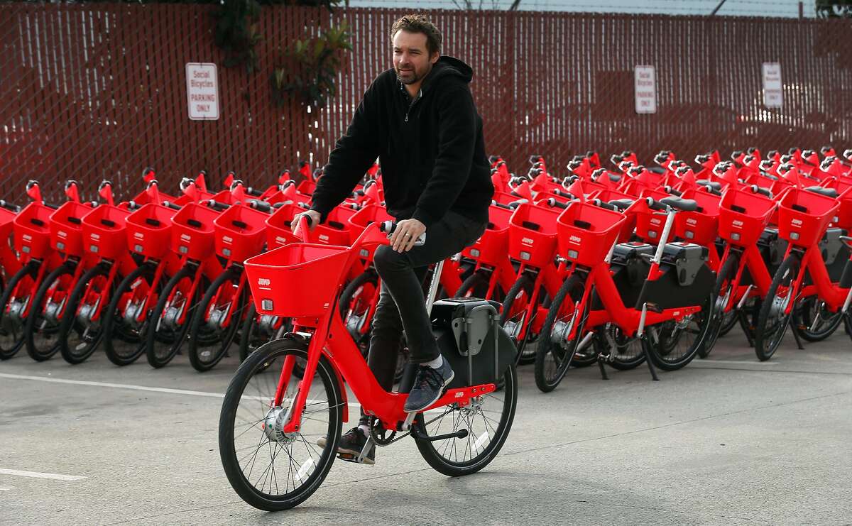 Jump Bike founder and CEO Ryan Rzepecki rides past some of the e-assist bicycles ready to hit the road in San Francisco, Calif. on Wednesday, Jan. 17, 2018. Jump is deploying 250 of the bike-share electric bicycles on the streets of the city Thursday and have plans to add another 250 to the fleet later in the year.