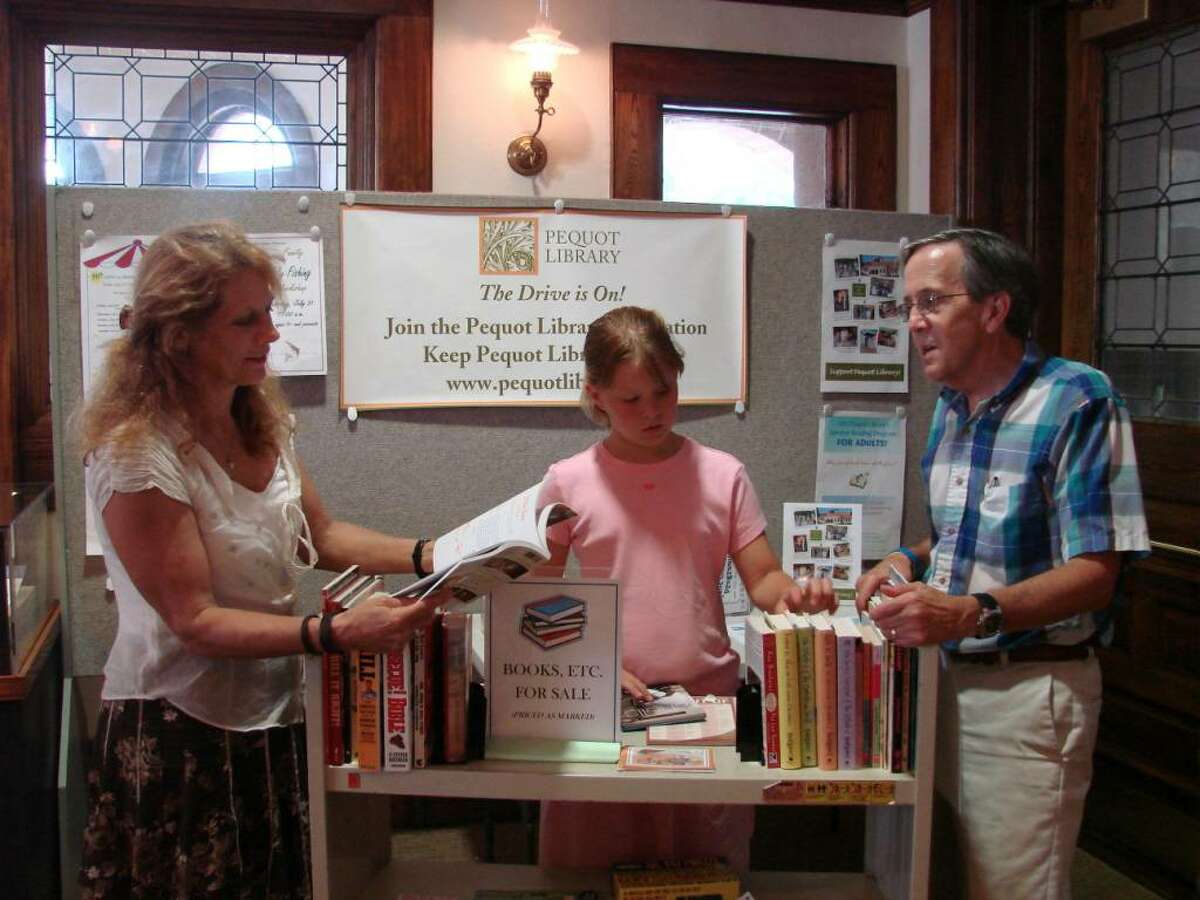 Getting ready for the 50th annual Pequot Library book sale are Susan Ei, children's librarian; volunteer Charlotte Meyer; and Dan Snydacker, executive director of the Pequot Library.
