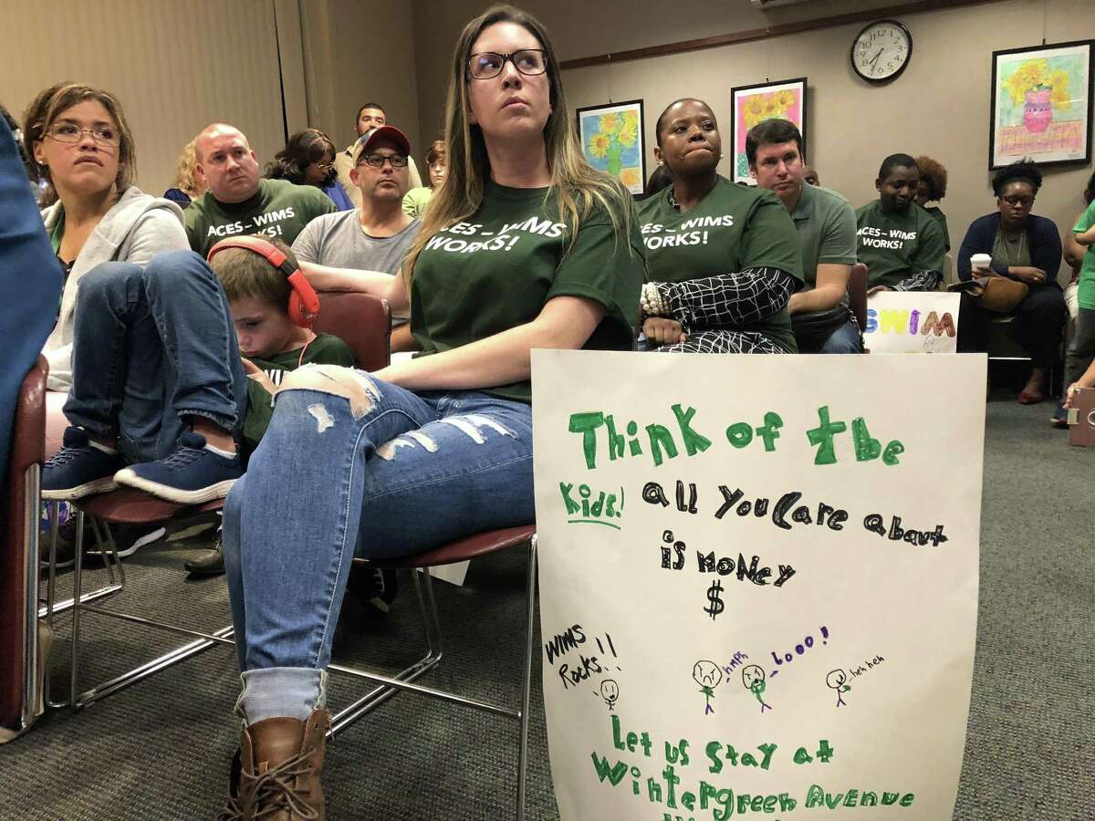 Parent Mary Kate Kelly, holding sign, and other parents and community members from the Wintergreen Interdistrict Magnet School lobbied the Board of Education Tuesday not to force students and the program out of the building, as would occur under recent redistricting proposals.
