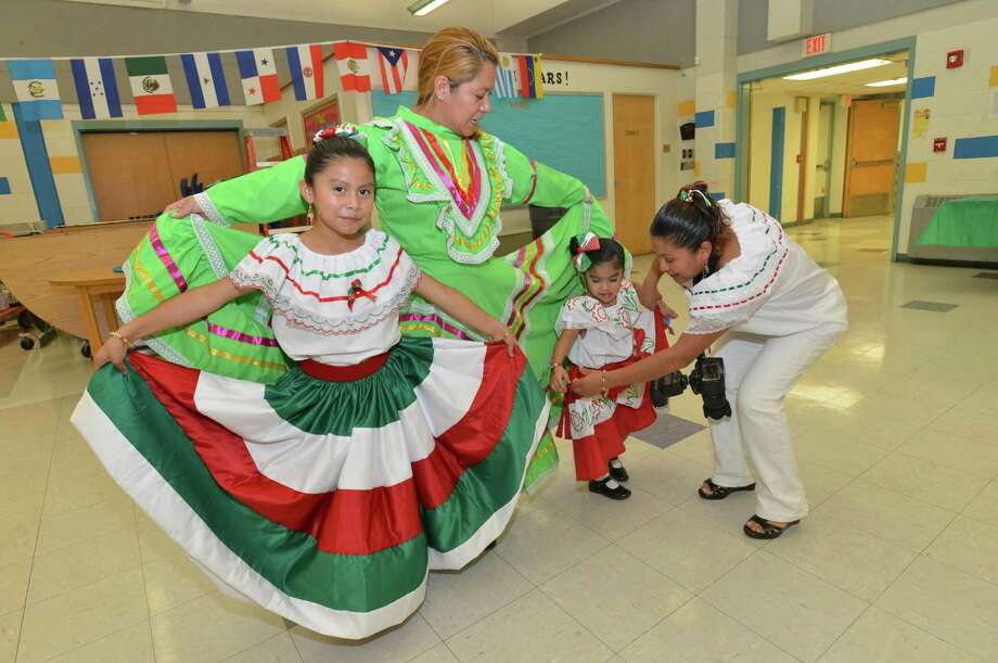 Guadalupe Marcelino and her nieces Emily and Leslie Marcelino get a hand fanning out their traditional Mexican dresses during the Fox Run School's Resource Center's Hispanic Heritage Celebration on Wednesday October 10, 2018 in Norwalk Conn. Photo: Alex Von Kleydorff / Hearst Connecticut Media / Norwalk Hour