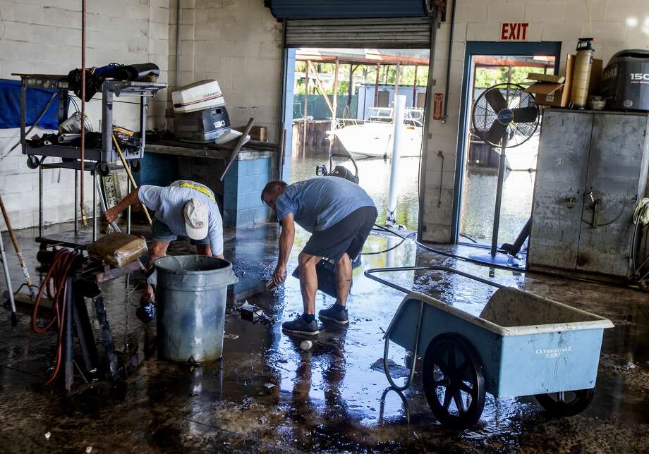Employees at Shields Marina clean up the mud deposited by the storm surge from Hurricane Michael on October 11, 2018 in Saint Marks, Florida. The hurricane hit the Florida Panhandle as a category 4 storm. Photo: Mark Wallheiser/Getty Images