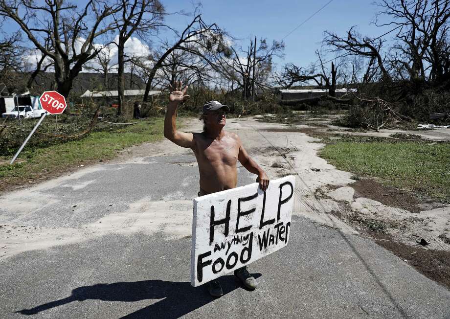 Michael Williams, 70, waves to passing motorists while looking for food and water as downed trees prevent him from driving out of his damaged home with his family in the aftermath of Hurricane Michael in Springfield, Fla., Thursday, Oct. 11, 2018. "I don't know what I'm going to," said Williams. (AP Photo/David Goldman) Photo: David Goldman/AP