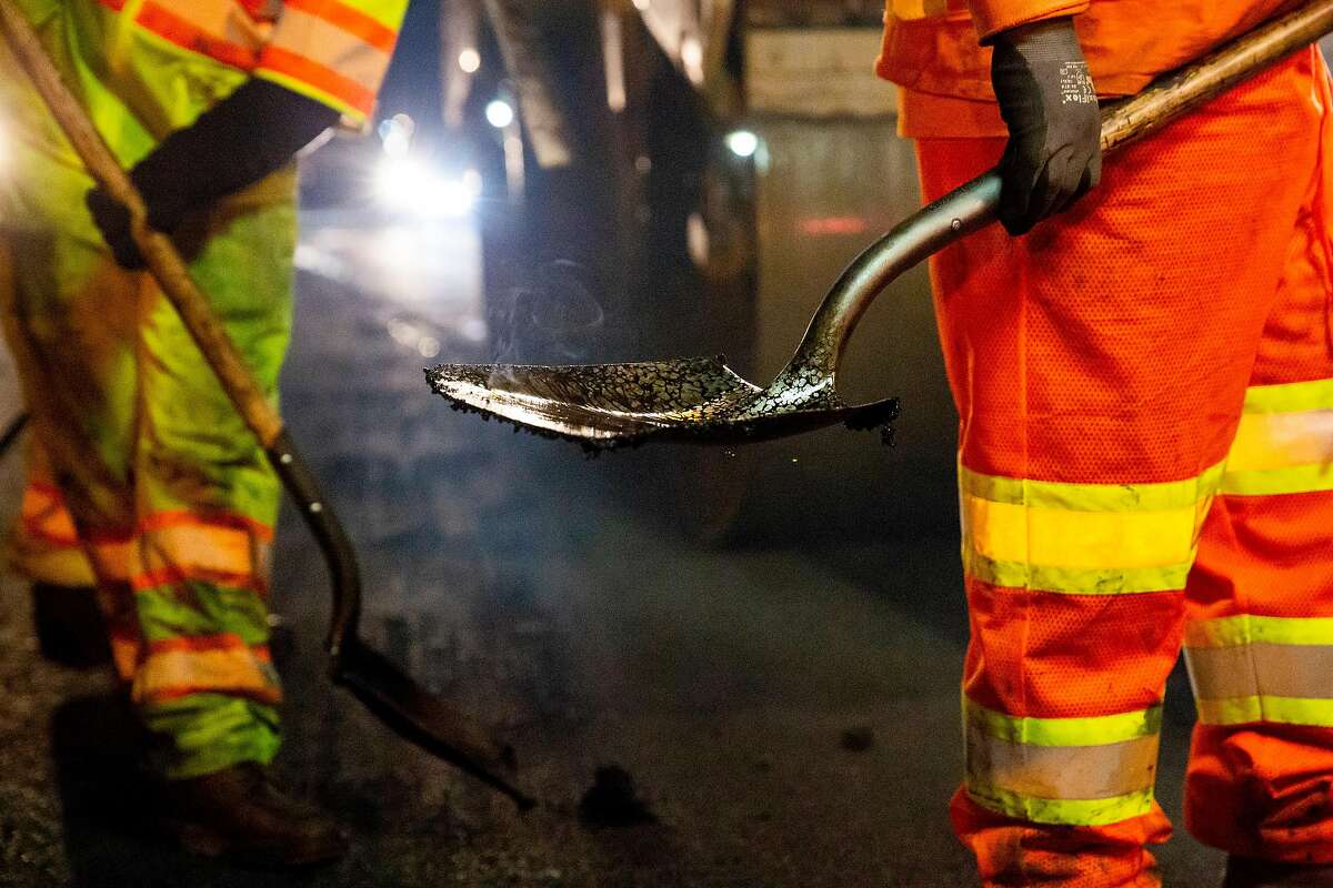 Steam rises from a shovel as O.C. Jones and Sons contractors working with CalTrans pave rubberized hot-mix asphalt on two of the Southbound lanes of the I-880 freeway in Hayward, Calif. on Wednesday, Oct. 9, 2018.