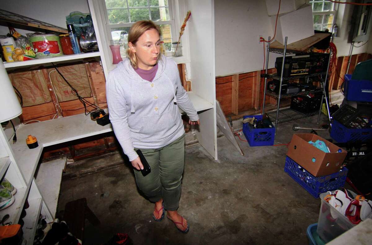 Renwick Drive resident Agnieszka Magtangob explains how much damage was done to her home from recent flooding in Bridgeport, Conn., on Thursday Oct. 11, 2018. Many homes in the neighborhood were damaged by the flooding of the Rooster River after a heavy rainstorm on Tuesday Oct. 2, 2018. Residents are angry that they have not been able to get any aid from FEMA because the mayor did not declare the area a disaster area.