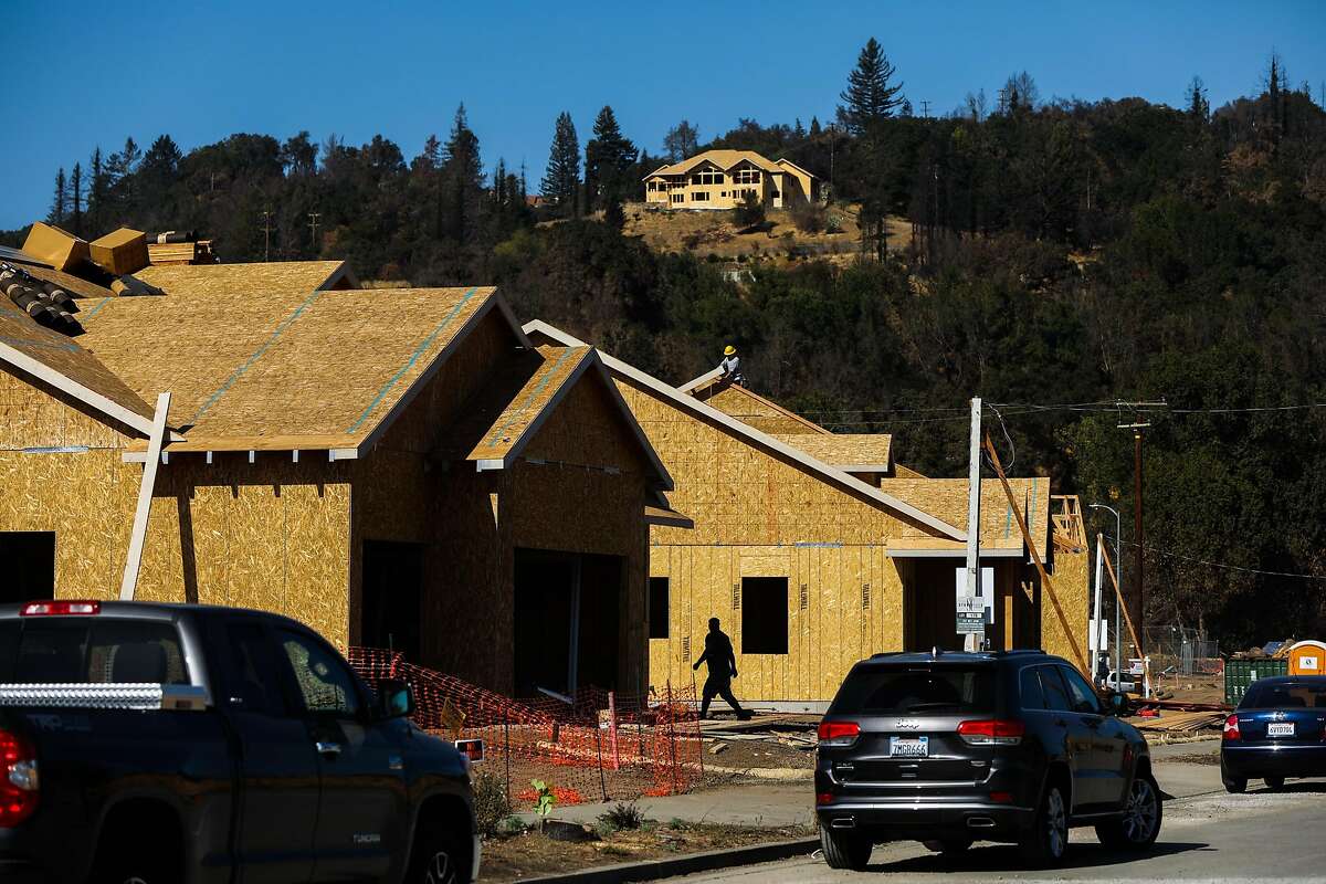 Construction workers build houses on Pacific Heights Drive after the Tubbs fire destroyed the neighborhood last year in Santa Rosa, California, on Friday, Sept. 28, 2018.
