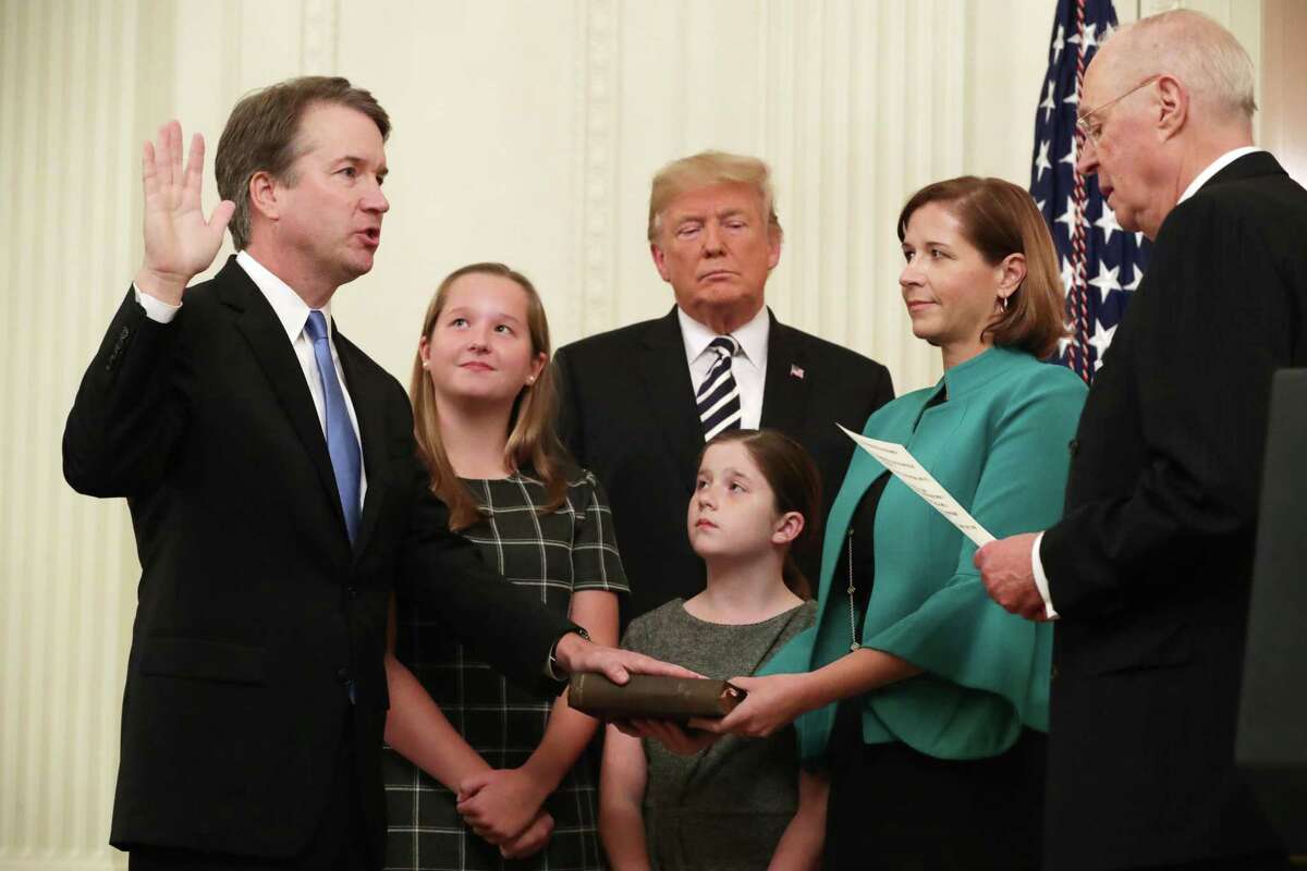 U.S. Supreme Court Justice Brett Kavanaugh (L) participates in a ceremonial swearing in by retired Justice Anthony Kennedy (R) as President Donald Trump, Kavanaugh's wife Ashley, youngest daughter Liza and oldest daughter Margaret look on in the East Room of the White House October 08, 2018 in Washington, DC.