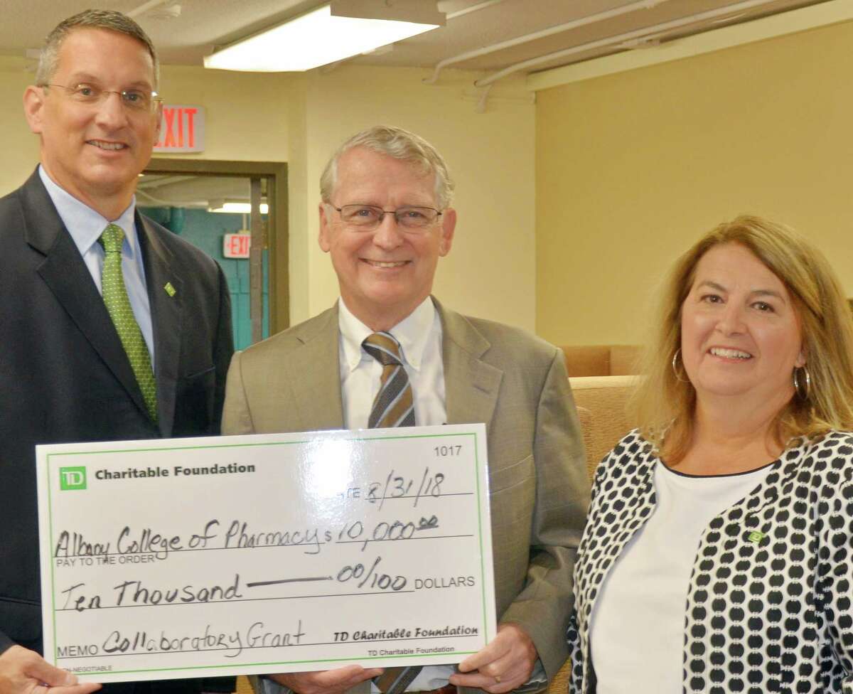 James Gaspo, Upstate NY Regional Vice President at TD Bank (left) and Francine Yanulavich, TD Bank?s Vice President and Field Marketing Manager (right), present Albany College of Pharmacy and Health Sciences President Greg Dewey with a $10,000 check on behalf of the TD Charitable Foundation. The funds will help ensure The Collaboratory ? a new community health resource opened by the College and located in Albany?s South End ? has the resources needed to provide a range of social and health care services for area residents.