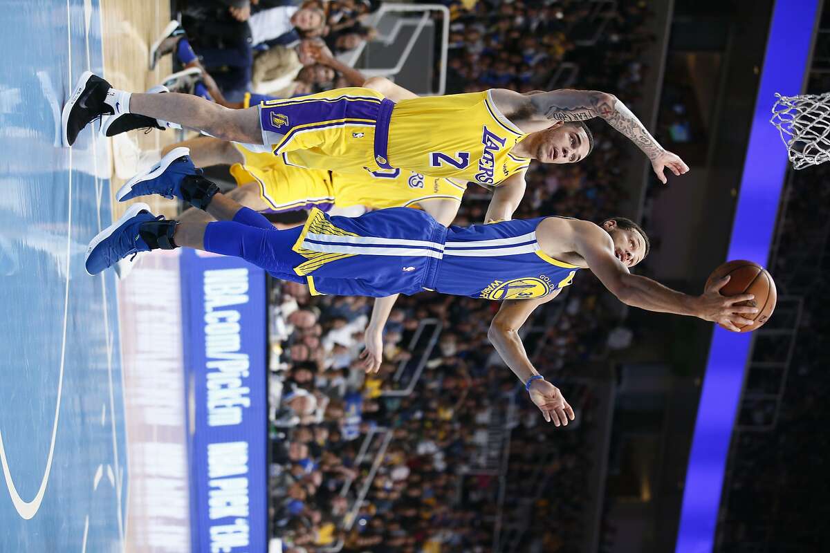 Golden State Warriors guard Stephen Curry (30) with a reverse lay-up shot against Los Angeles Lakers guard Lonzo Ball (2) during the first quarter of an NBA preseason game at SAP Center on Friday, Oct. 12, 2018, in San Jose, Calif.