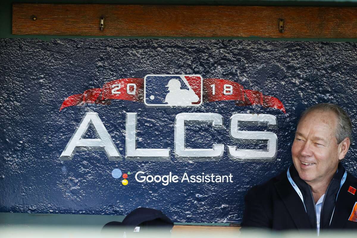 Astros owner Jim Crane sits in the Astros dugout before batting practice before Game 1 of the American League Championship Series at Fenway Park on Saturday, Oct. 13, 2018, in Boston.