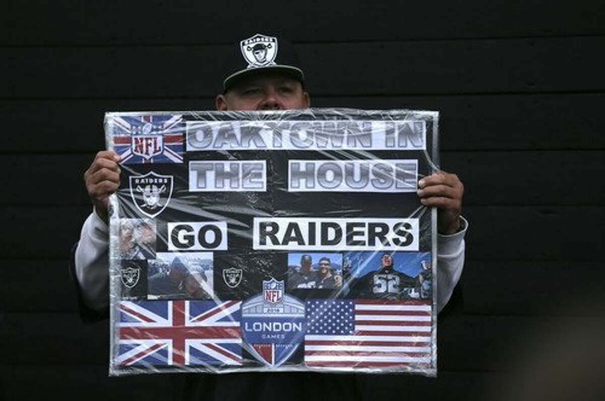 An Oakland Raiders supporter poses for a photo on Wembley Way before an NFL football game against Seattle Seahawks at Wembley stadium in London, Sunday, Oct. 14, 2018. (AP Photo/Tim Ireland)