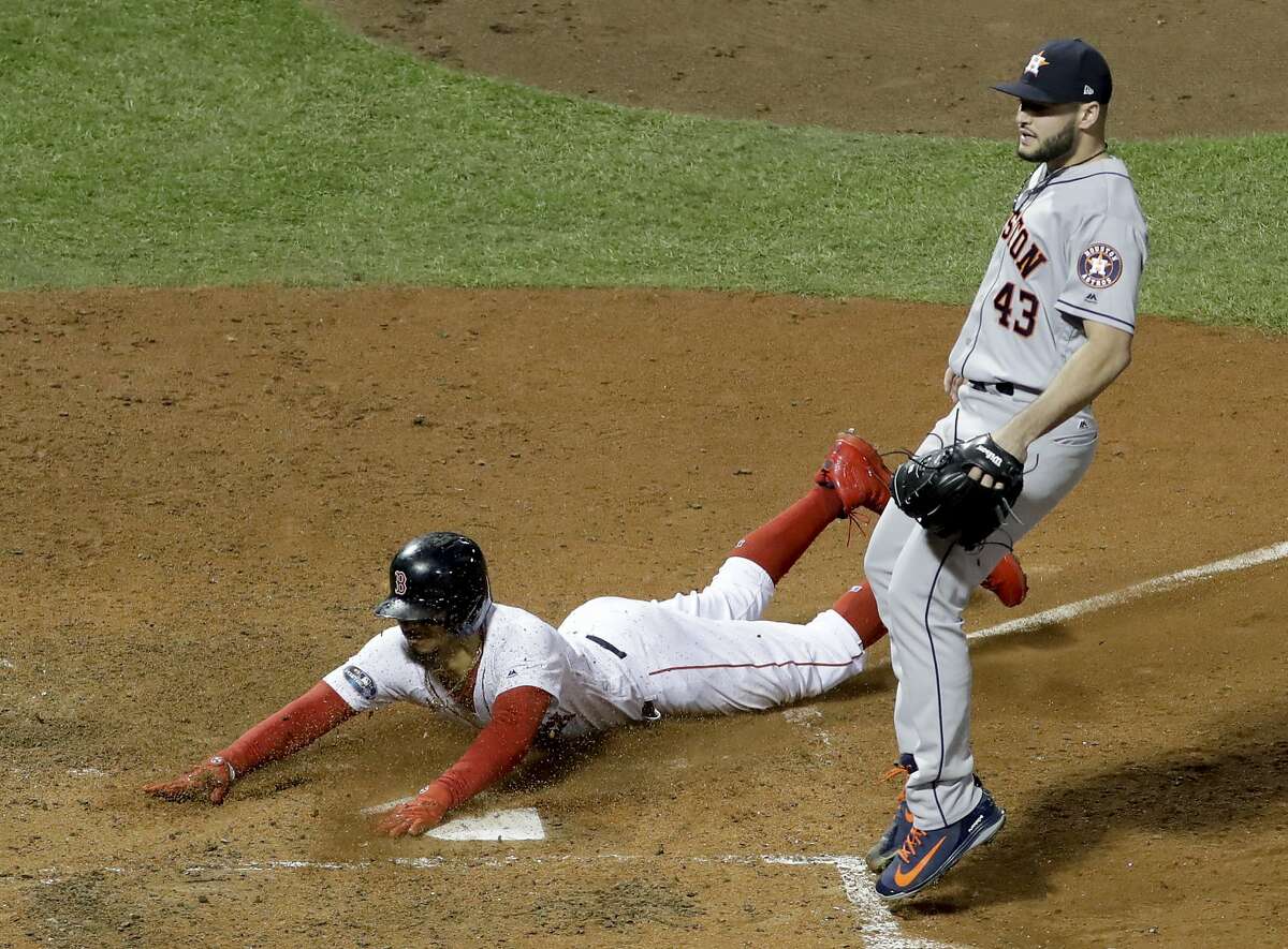 Boston Red Sox's Mookie Betts scores by Houston Astros pitcher Lance McCullers Jr. on a passed ball during the seventh inning in Game 2 of a baseball American League Championship Series on Sunday, Oct. 14, 2018, in Boston. (AP Photo/David J. Phillip)