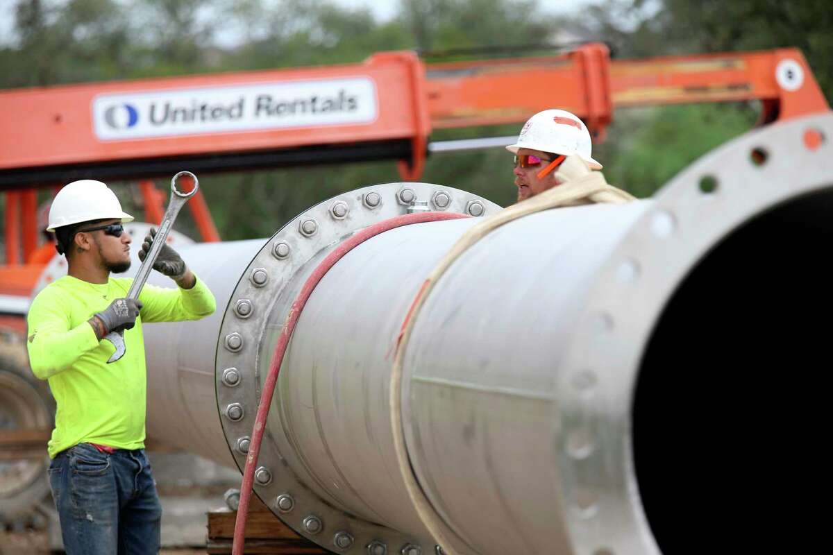 Ishmael Martinez, left, and John Grimes work on an outlet pipe at the Agua Vista Station in the Stone Oak area in October 2018. The 80-foot-tall tank is designed to hold 10 million gallons of water from the Vista Ridge pipeline, running from Burleson County to San Antonio. The station has two tanks and can treat 45 million gallons of water a day. The tanks are each made of 47 wall panels and 80 dome panels.