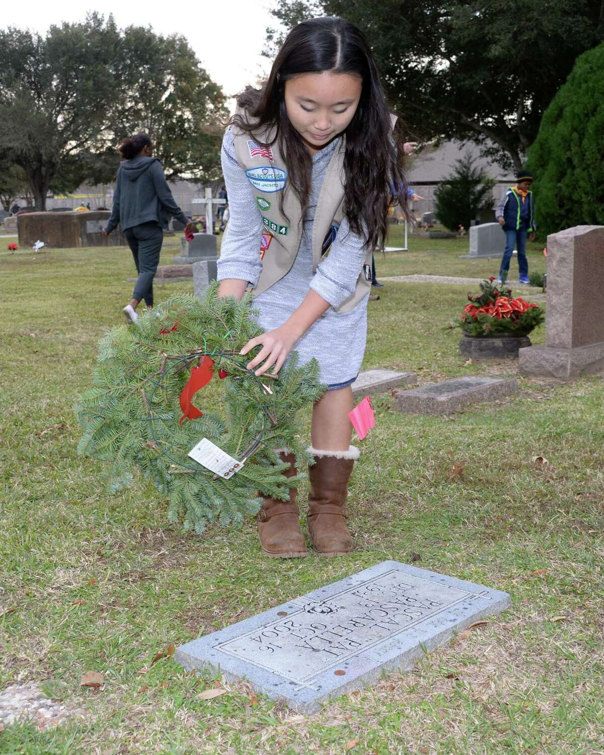 Katelyn Nitsche of Girl Scout Troop 17384 lays a wreath on a veteran's grave during the Wreaths Across America Ceremony at the Magnolia Cemetery in Katy, TX on Saturday, December 16, 2017.