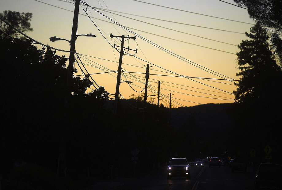 Power transmission lines cross a street in Sonoma, Calif., on Monday, Oct. 15, 2018. Some customers in the region remain without power after PG&E cut electric service in hopes of preventing fires amid red flag fire warnings. Photo: Noah Berger / SFC