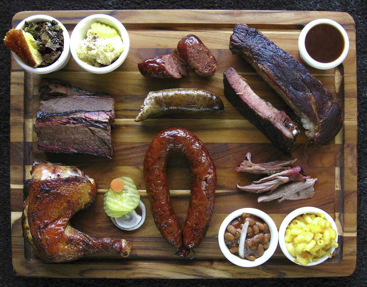 Barbecue and sides from Ed's Smok-N-Q. Clockwise from top left: cornbread, collard greens, potato salad, Yoakum link sausage, pork spare ribs, barbecue sauce, pulled pork, mac and cheese, baked beans, Schulenburg ring sausage, chicken, brisket and Port Arthur boudin sausage.