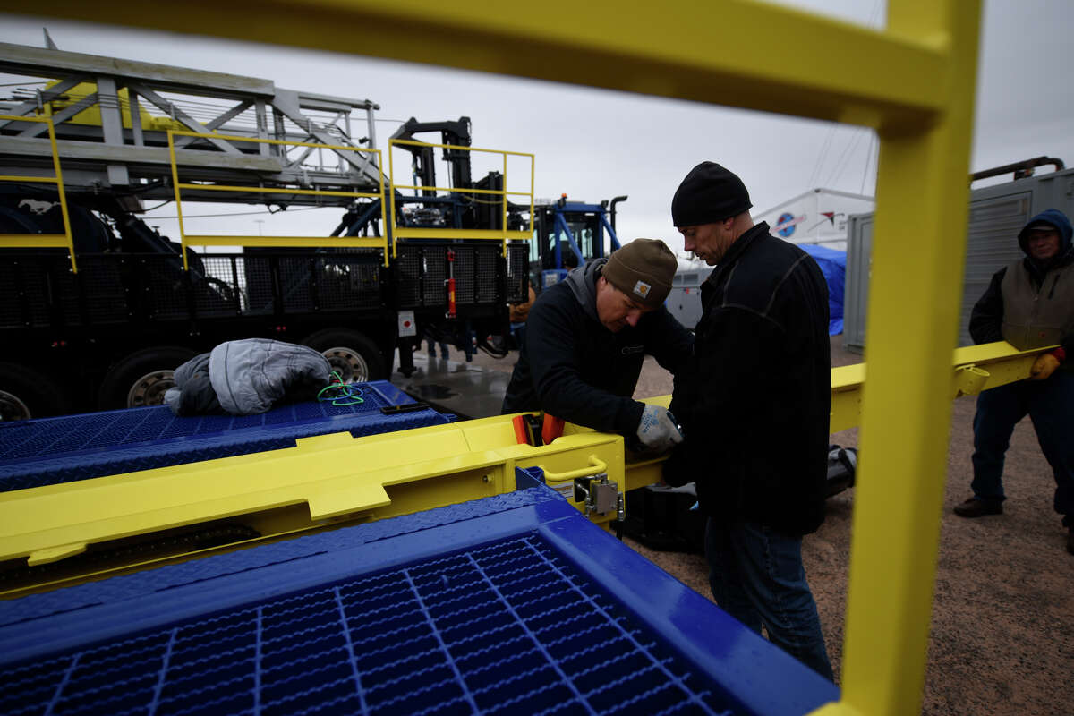 Michael Andreas, left, and Michael Jeseritz, right, set up Hawker Well Works equipment in preparation for the Permian Basin International Oil Show Oct. 15, 2018 at the Ector County Colseum. James Durbin/Reporter-Telegram