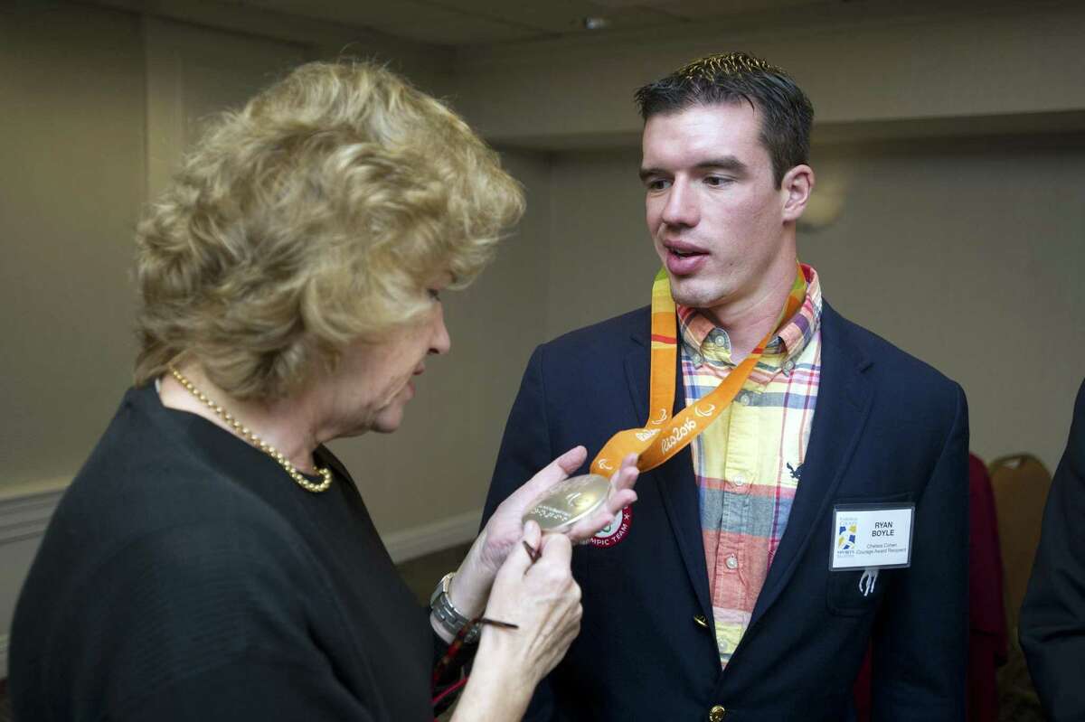 Barbara Rittner, the mother of the late Chelsea Cohen, looks at the 2016 silver medal of Ryan Boyle, the recipient of the 2018 Chelsea Cohen Courage Award, during the Fairfield County Sports Commision's Sports Night at the Stamford Marriott in downtown Stamford, Conn. on Monday, Oct. 15, 2018.