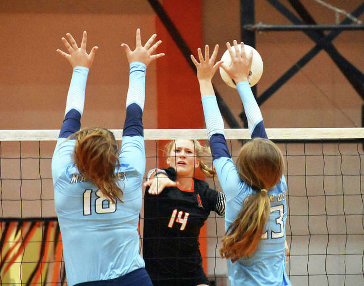 Edwardsville’s Maddie Isringhausen, center, tries to slam a kill through the block of two Mater Dei players in the first game.