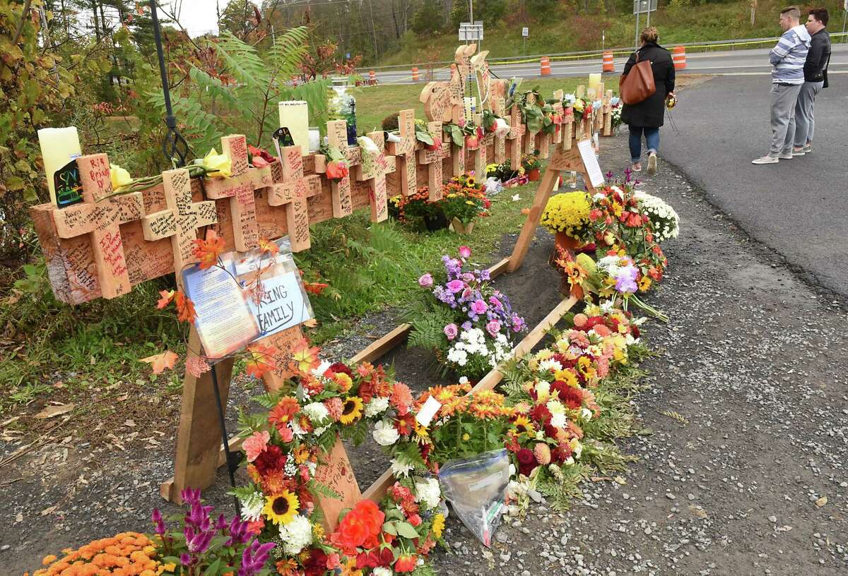 People visit a growing memorial for the Schoharie limo crash victims at the site of the accident next to the Apple Barrel Store on Monday, Oct. 15, 2018 in Schoharie, N.Y. (Lori Van Buren/Times Union)