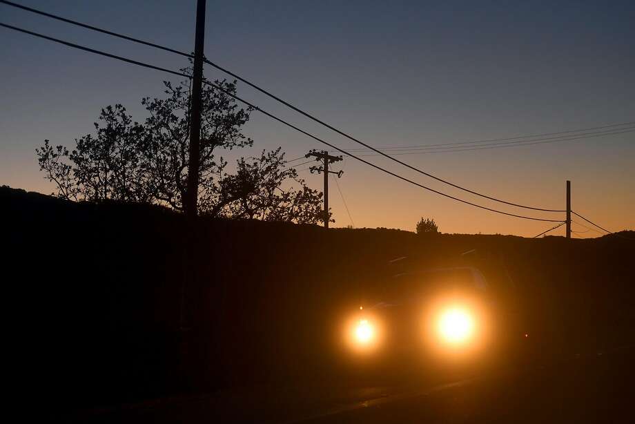 A car passes power lines Highway 12 near Glen Ellen, Calif., on Monday, Oct. 15, 2018. Some customers in the region remain without power after PG&E cut electric service in hopes of preventing fires amid red flag fire warnings. Photo: Noah Berger / The Chronicle