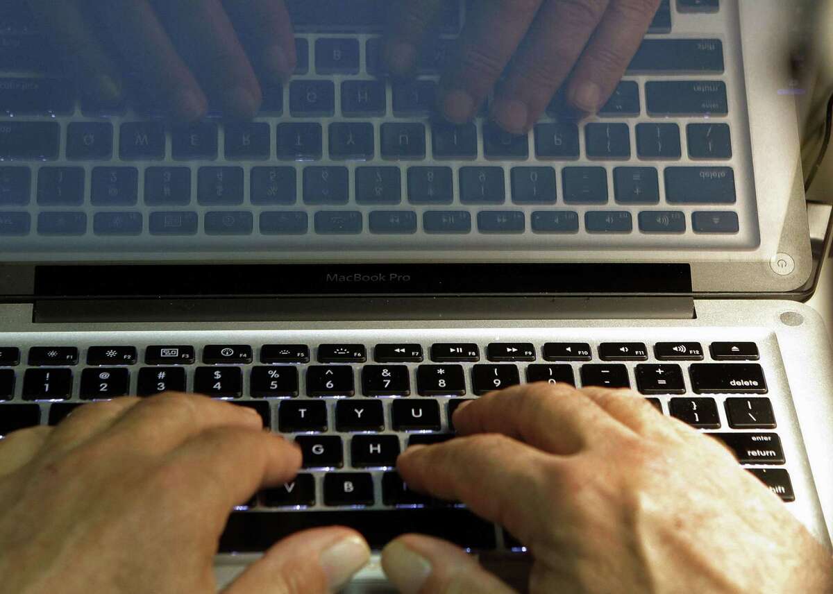 FILE - In this Wednesday, Feb. 27, 2013 photo illustration, hands type on a computer keyboard in Los Angeles. In the wake of the Heartbleed security threat, many security experts recommend a second layer of authentication _ typically in the form of a numeric code sent as a text message. You enter that code on the website to verify that itâ??s really you and not a hacker who doesnâ??t have your phone. (AP Photo/Damian Dovarganes, File)