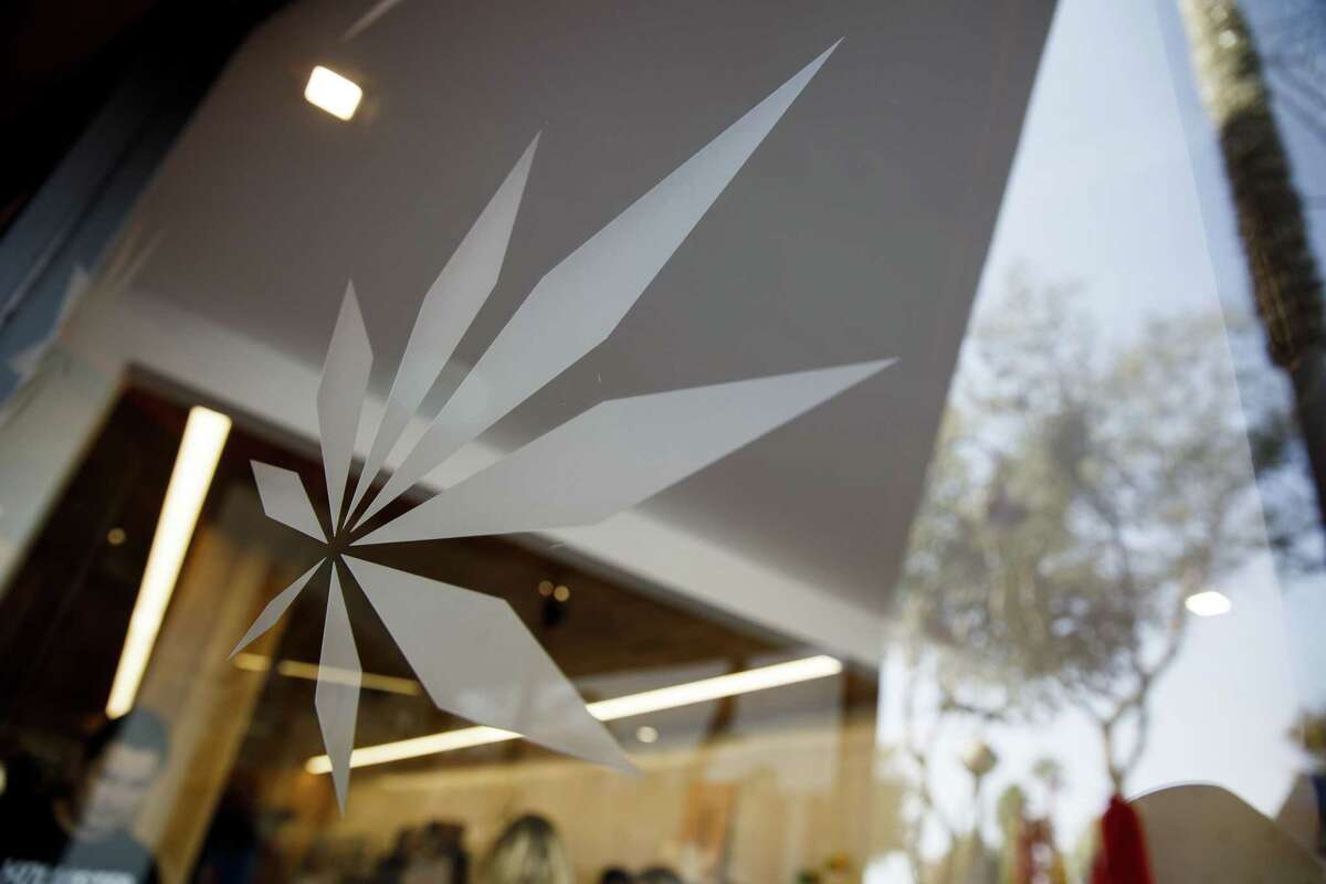 A marijuana leaf design is seen in the window of the MedMen dispensary in West Hollywood, California, in 2018. MedMen is now poised to settle an ongoing lawsuit and sell its New York operations to Ascend Wellness Holdings. (Patrick T. Fallon/Bloomberg)