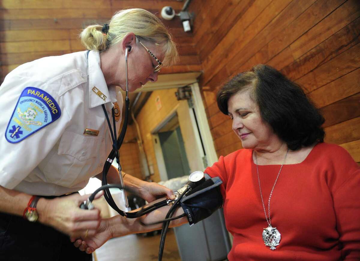 GEMS paramedic Lynn Ridberg checks Riverside’s Rose Revel in October 2018 at the Health & Wellness Expo in Old Greenwich, Conn. Five of Connecticut’s six health insurance carriers added to their membership rolls last year as tracked by the Connecticut Insurance Department, whether for full coverage or partial indemnity and HMO plans that exclude some types of coverage.