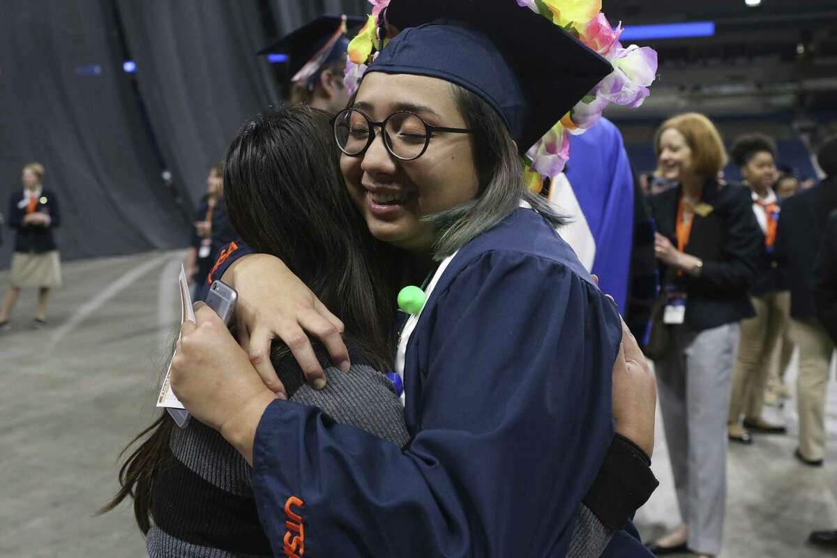 Business major Joanna Gallegos, 22, of Houston, hugs her friend, Sara de Leon, 20, of Brownsville, before the University of Texas at San Antonio December commencement ceremony at the Alamodome, Sunday, Dec. 17, 2017. More than 3,100 undergraduate students, 700 master's students and nearly 100 doctoral students are eligible to attend this commencement.