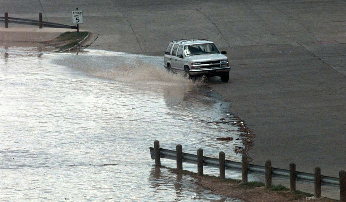 A vehicle splashes in rising flood waters near the Jaurez-Lincoln International Bridge in Laredo, Texas, Wednesday, Aug. 26, 1998. The flood crest of the Rio Grande is expected at midnight.