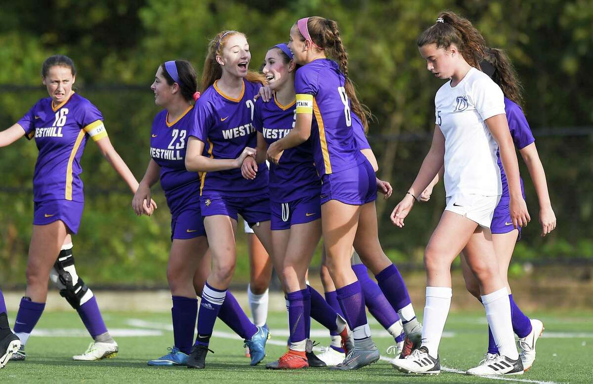 Westhill's Corinne Dente (9), center, celebrates her goal against Darien in the first half of an FCIAC girls soccer game in Stamford, Connecticut., Tuesday, Oct. 16, 2018.