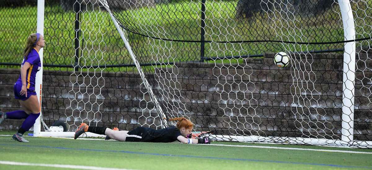 Westhill's Claudia Benz (6) watches as Darien goalkeeper Caroline Orphanos falls to the turf attempting to stop a goal by Corinne Dente (9) in the first half of an FCIAC girls soccer game in Stamford, Connecticut., Tuesday, Oct. 16, 2018.