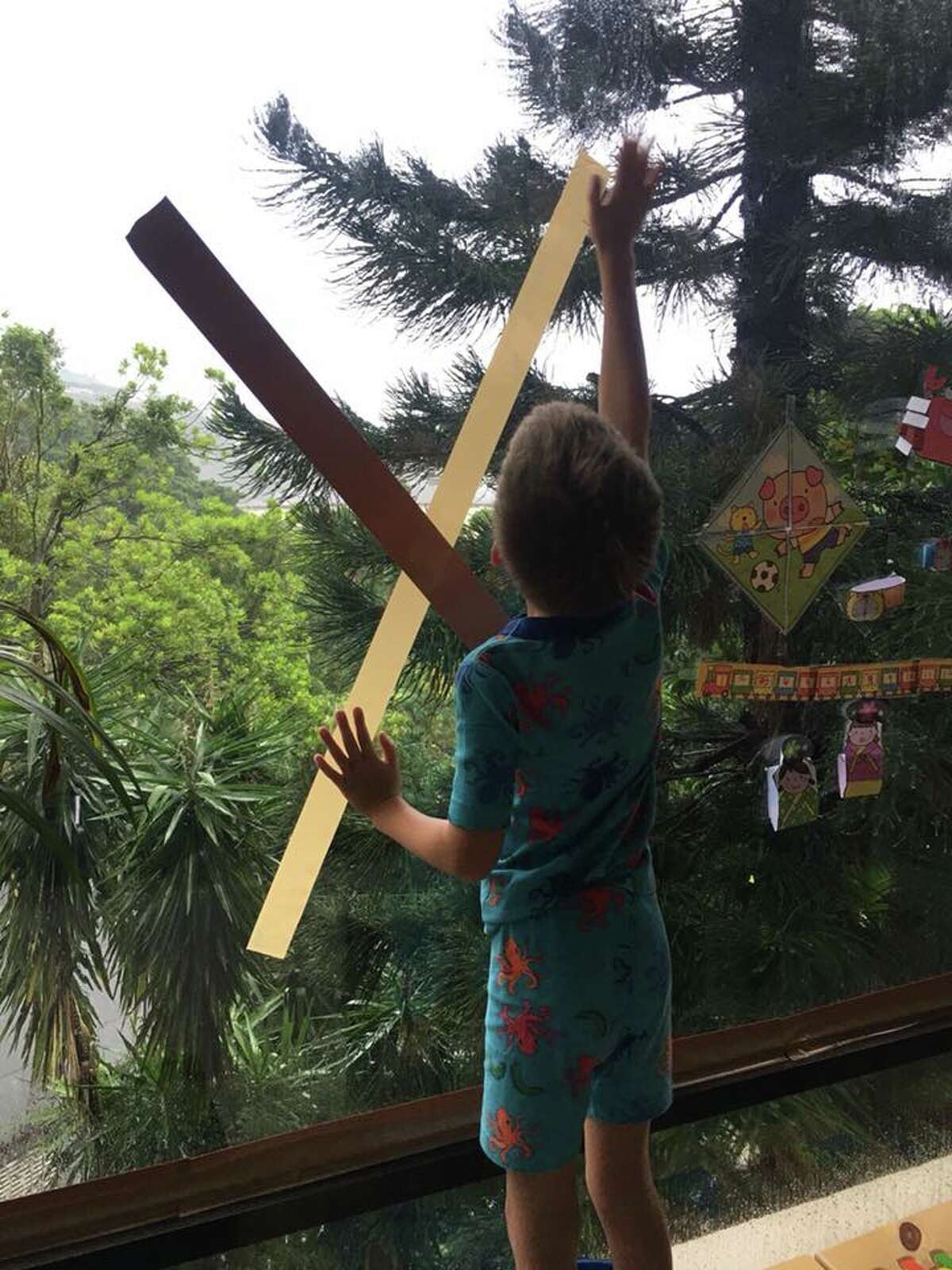 Knapp's grandson Cooper helping tape up windows before Typhoon Mangkhut arrives in Hong Kong.