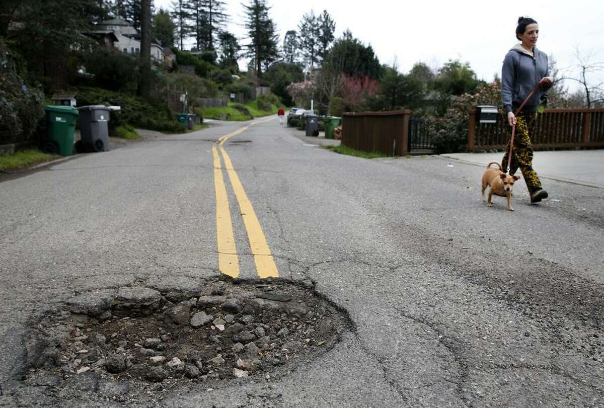 Potholes and other hazards like this one on Broadway Terrace in Oakland cost Bay Area drivers an estimated $1,049 a year.