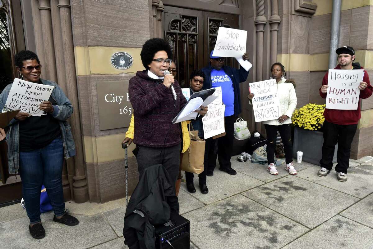 Kom Hart of Mothers & Others For Justice, left, and Kerry Ellington of the New Haven Legal Assistance Association, second from left with microphone, protest in front of New Haven City Hall Wednesday about the lack of affordable housing in New Haven.