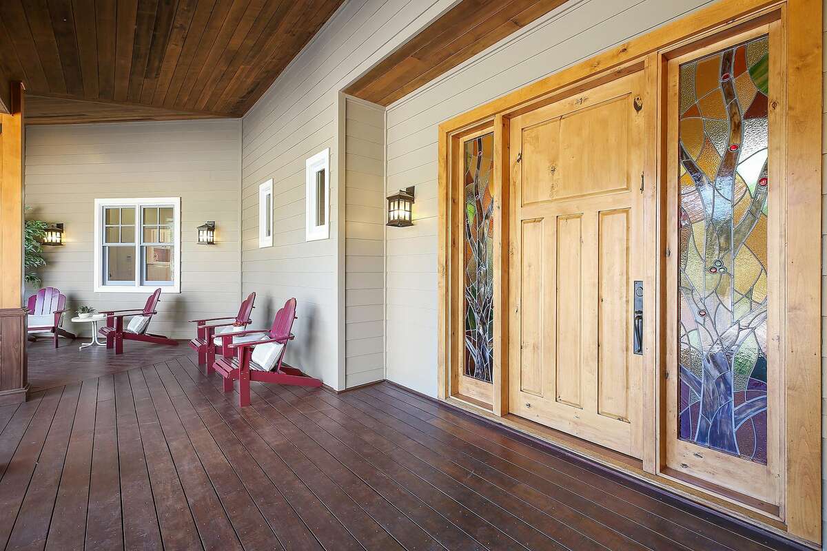 Stained glass windows stand beside the front door as a covered deck stretches before the Sonoma home.