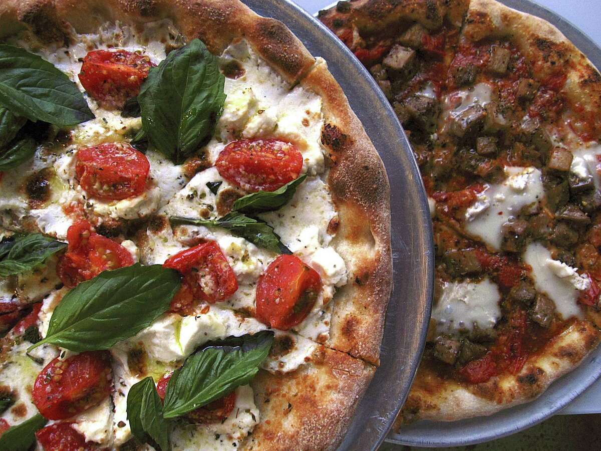 Roof Fire pizza, left, with cherry tomatoes, basil, mozzarella and ricotta and a Brie Real pizza with brie, eggplant, oregano and Campari tomato sauce from Playland.