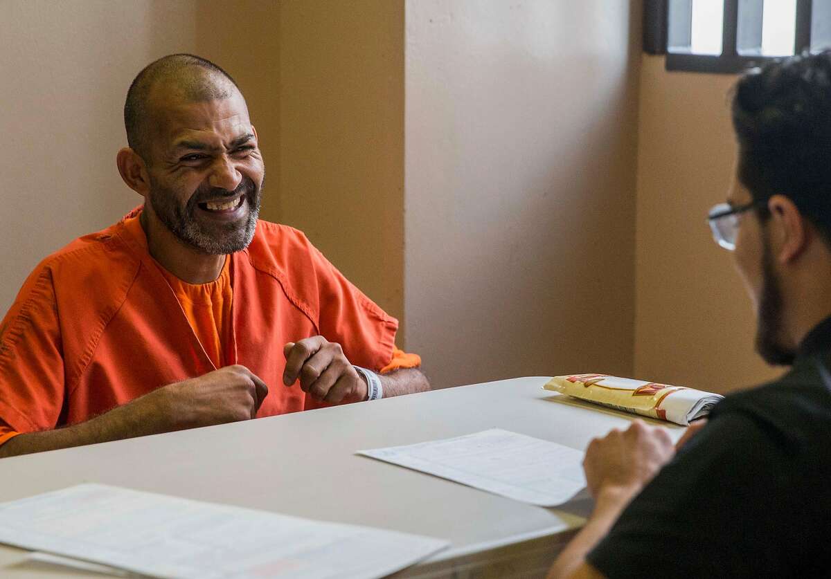 Glenn Dyer Detention Facility inmate Manish Sharma, 38, smiles after registering to vote for the first time with assistance from Alameda County Public Defender's Office Client Advocate Diego Cardenas, right, at Glenn Dyer Detention Facility in Oakland, Calif. Friday, Oct. 12, 2018.