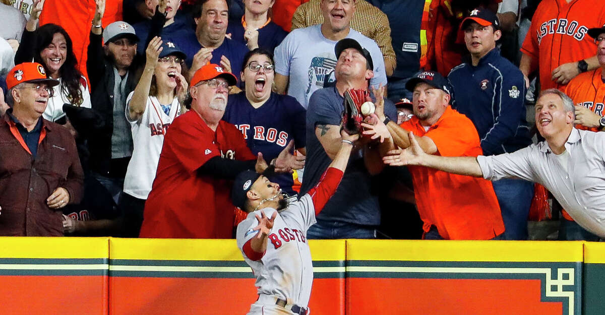 Red Sox right fielder Mookie Betts tries to catch a fly ball by Astros designated hitter Jose Altuve (27) during the first inning of Game 4 of the American League Championship Series on Oct. 17, 2018, in Houston. Altuve was called out on the play due to fan interference, wiping out a two-run home run that would've tied the score at 2.