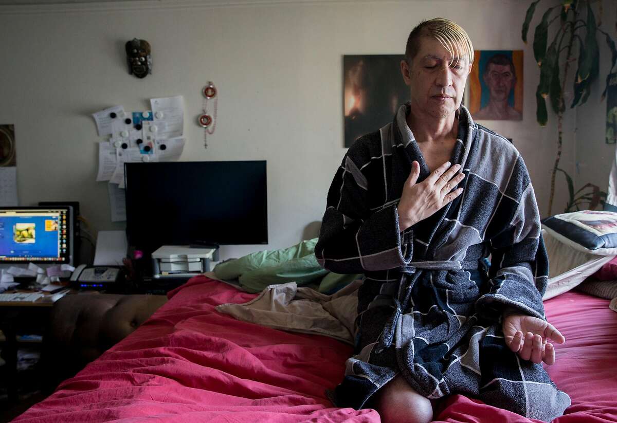 Jesus Guillen, a longterm HIV survivor, takes a moment to meditate in his bedroom before starting his day in San Francisco, Calif. Thursday, Oct. 18, 2018.