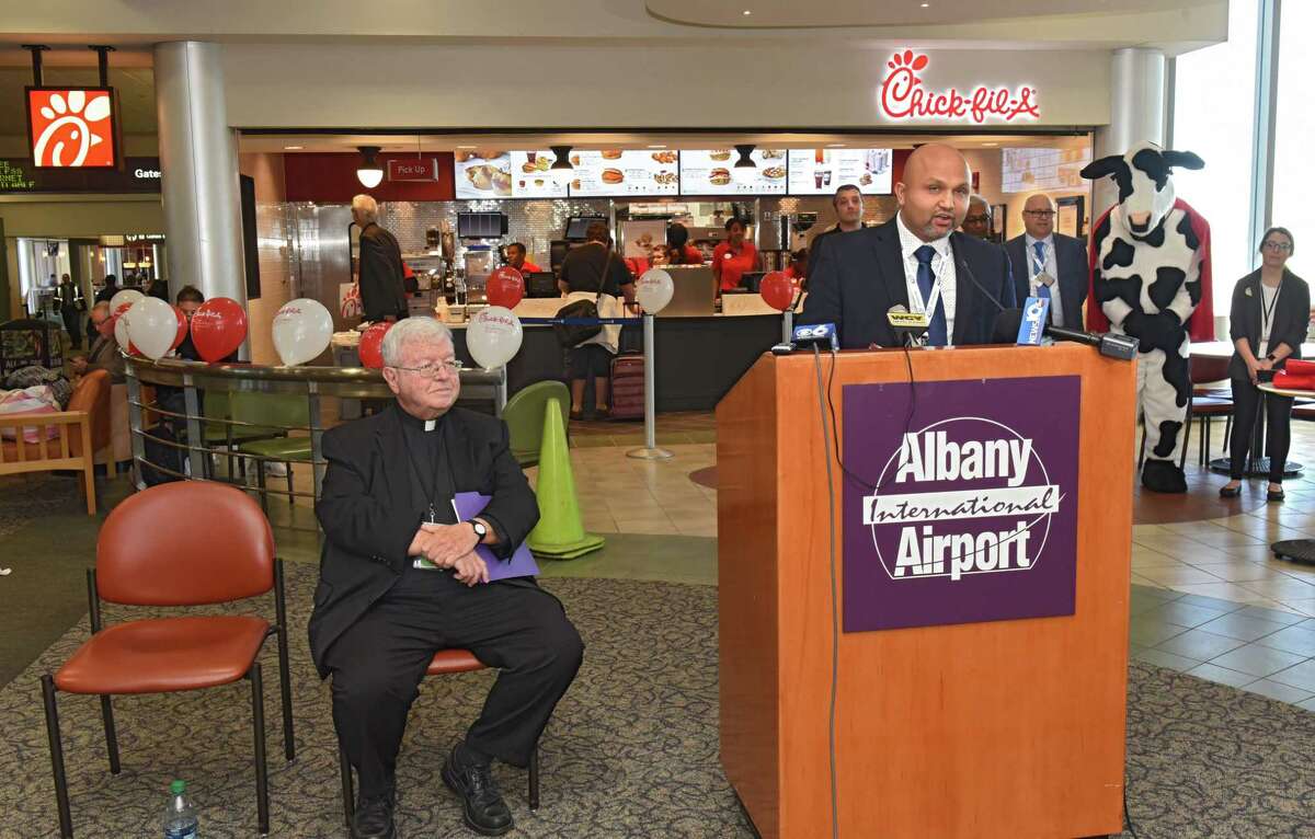Milan Patel, CEO and president of OHM Concessions Group, speaks as Albany International Airport hosts a Grand Opening Celebration for the area's first Chick-fil-A on Friday, Oct. 19, 2018 in Colonie, N.Y. Rev. Kenneth Doyle, chairman of the Albany County Airport Authority is seen at left. (Lori Van Buren/Times Union)