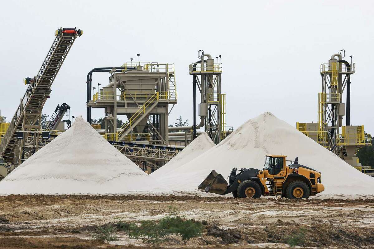 A WildHorse Resource Development front end loader drives past piles of sand for use in fracking operations at the new sand mine Tuesday Oct. 2, 2018 in Caldwell. Continue to get a look inside a frac sand mine operation. 